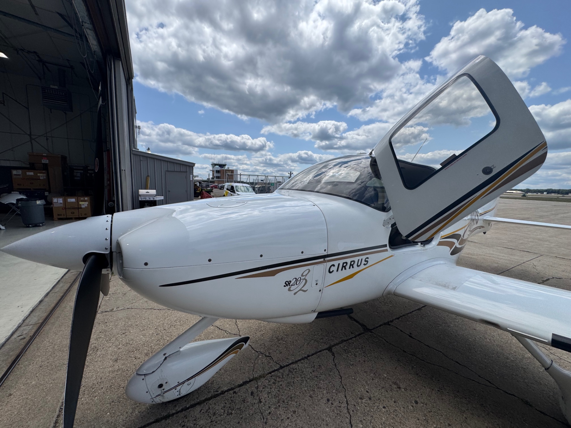 Cowling and propeller of a club Cirrus SR20-G2 at the hangar door